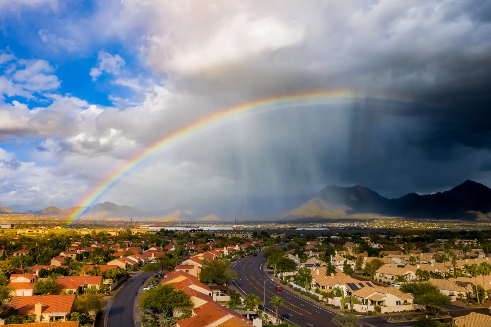 Rainbow over a desert community during a monsoon storm