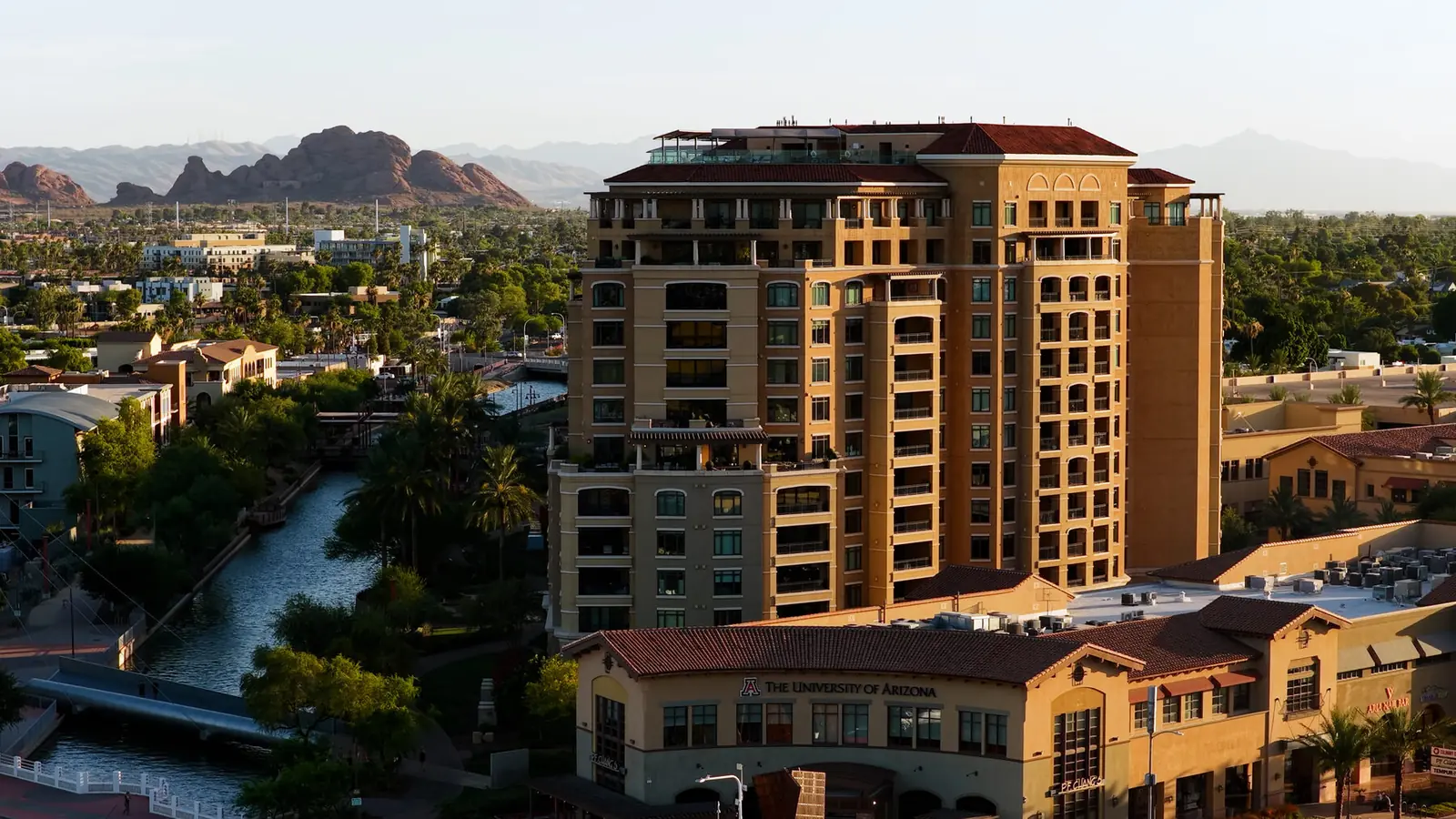 Canal separating a retail corridor from surrounding development at golden hour